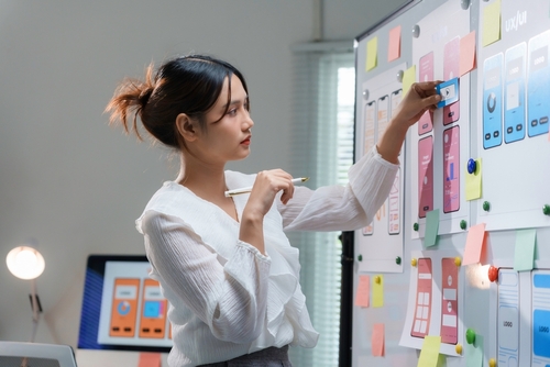 asian women organizing post its for website design project